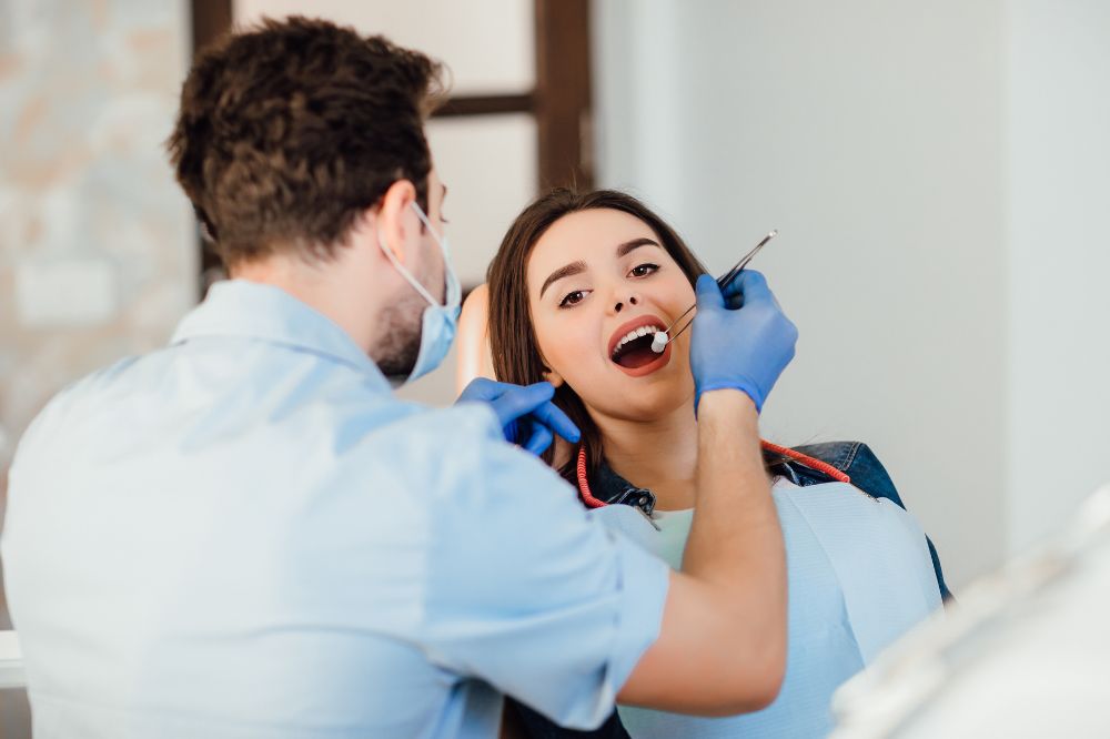 a woman is getting dental treatment.
